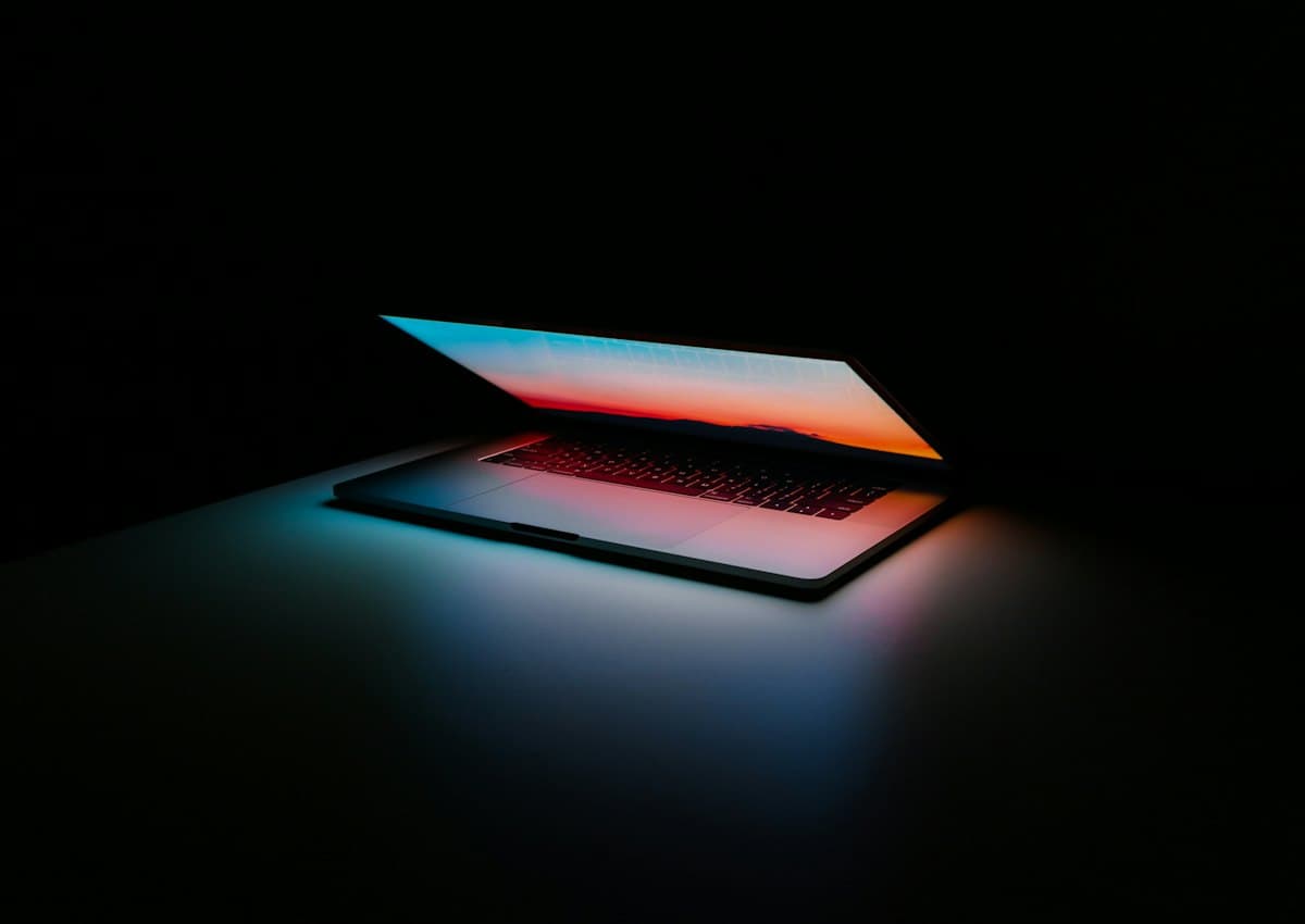 A laptop glowing in a dark room